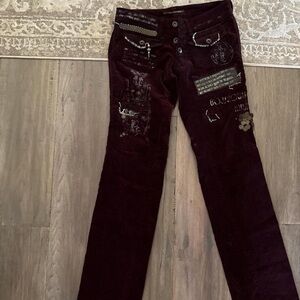 Burgundy and black velvet punk jeans with patches and charms has a slight flare
